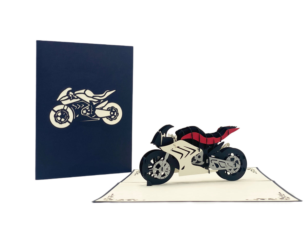 Aufgeklappte Pop-up-Karte mit Rennmaschine, daneben die dunkelblaue Kartenvorderseite mit Motorrad-Scherenschnitt.
