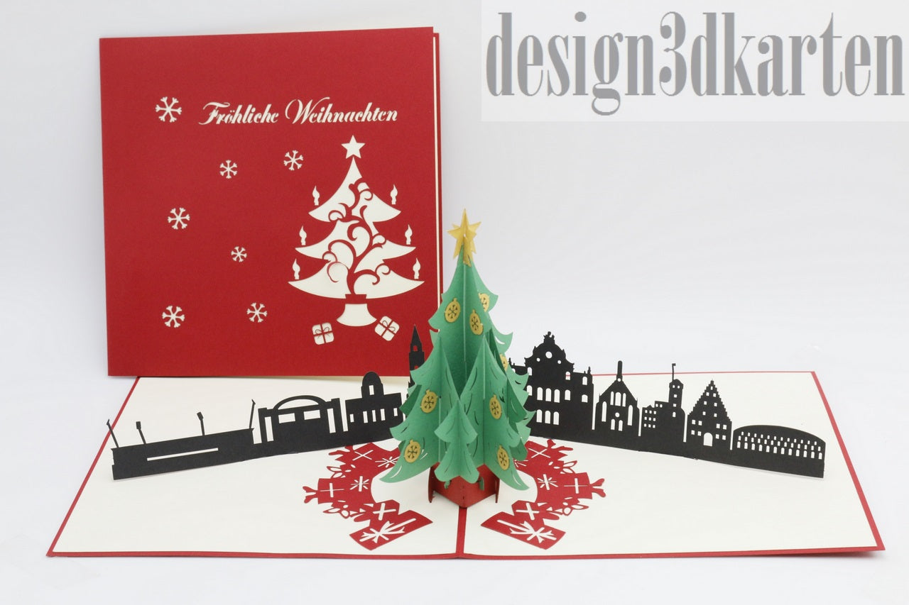 Aufgeklappte Pop-up-Karte mit Weihnachtsbaum und Nürnberger Skyline, daneben die rote Kartenvorderseite mit Weihnachtsbaum-Scherenschnitt.