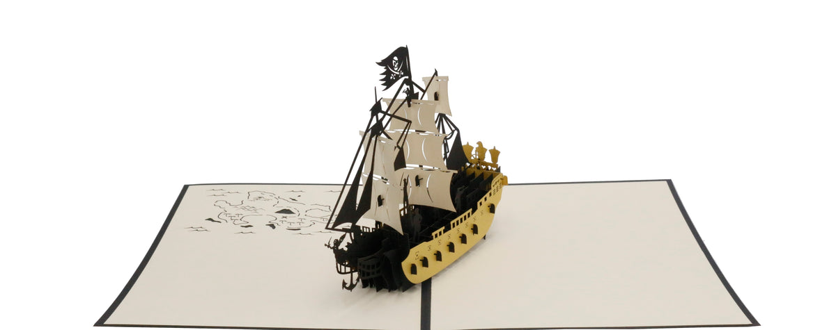 Aufgeklappte Pop-up-Karte mit einem Piratenschiff aus Papier, frontal fotografiert.