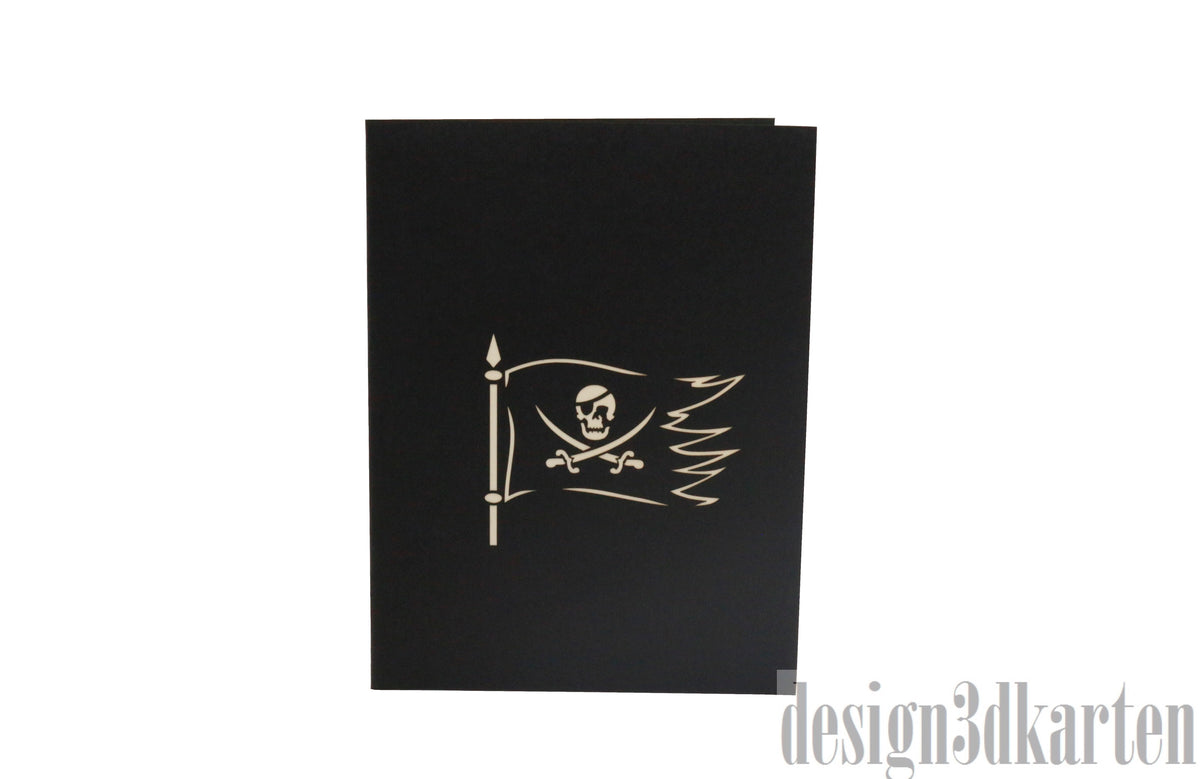 Schwarze Kartenvorderseite mit Piratenflagge, Säbel und Totenkopf als Scherenschnitt.