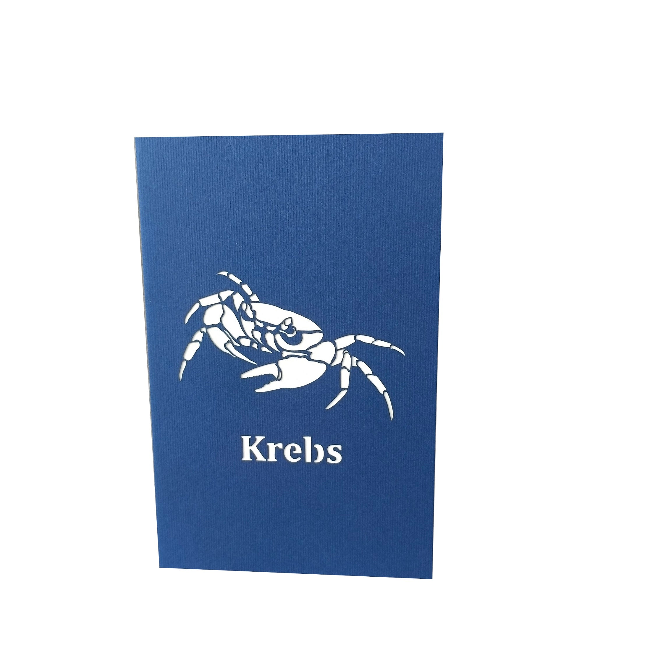 Dunkelblaue Kartenvorderseite mit dem Sternzeichen Krebs als Scherenschnitt und dem Schriftzug Krebs.