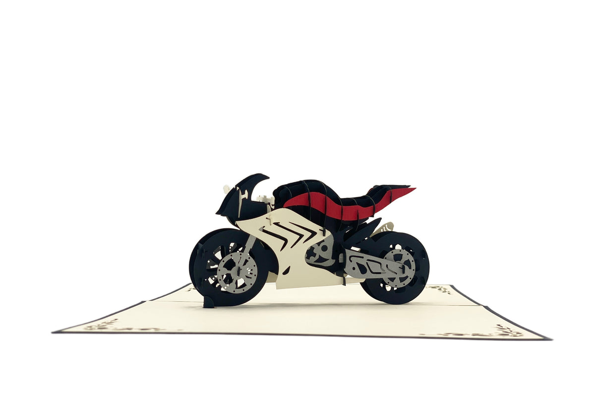 Aufgeklappte Pop-up-Karte mit Rennmaschine, frontal von der Seite fotografiert.