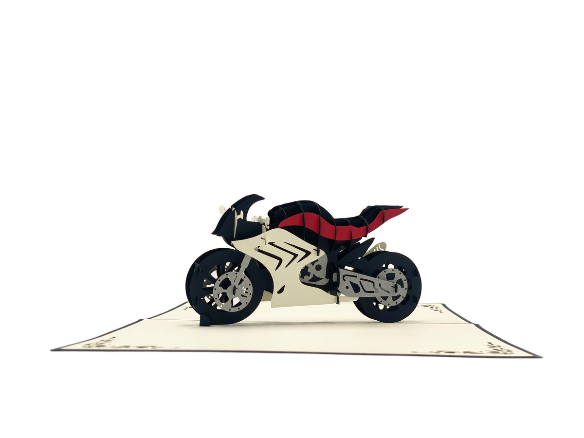 Aufgeklappte Pop-up-Karte mit Rennmaschine, frontal von der Seite fotografiert.