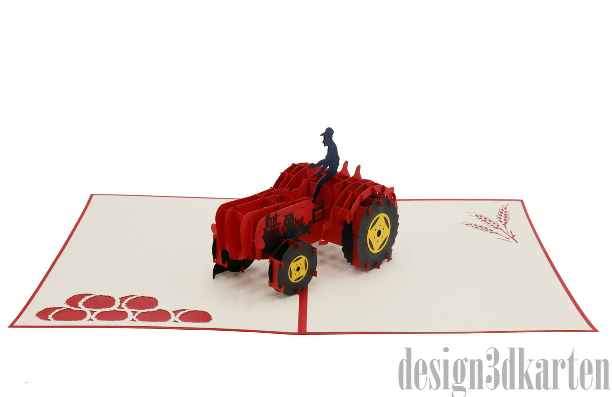Aufgeklappte Pop-up-Karte mit rotem Rand und einem roten Oldtimer-Traktor mit Fahrer, auf der Kartenfläche rote Äpfel.