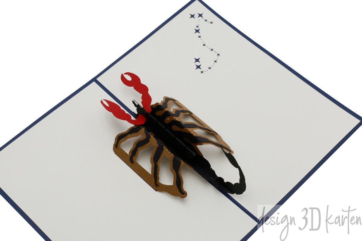 Aufgeklappte Pop-up-Karte mit einem Skorpion aus Papier, schräg von oben fotografiert.