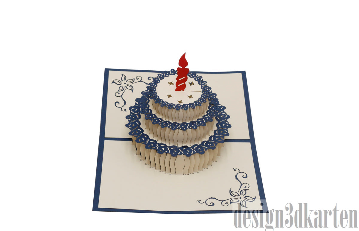 Aufgeklappte Pop-up-Karte mit blauem Rand und einer Torte mit roter Kerze und blauem Spitzendekor.