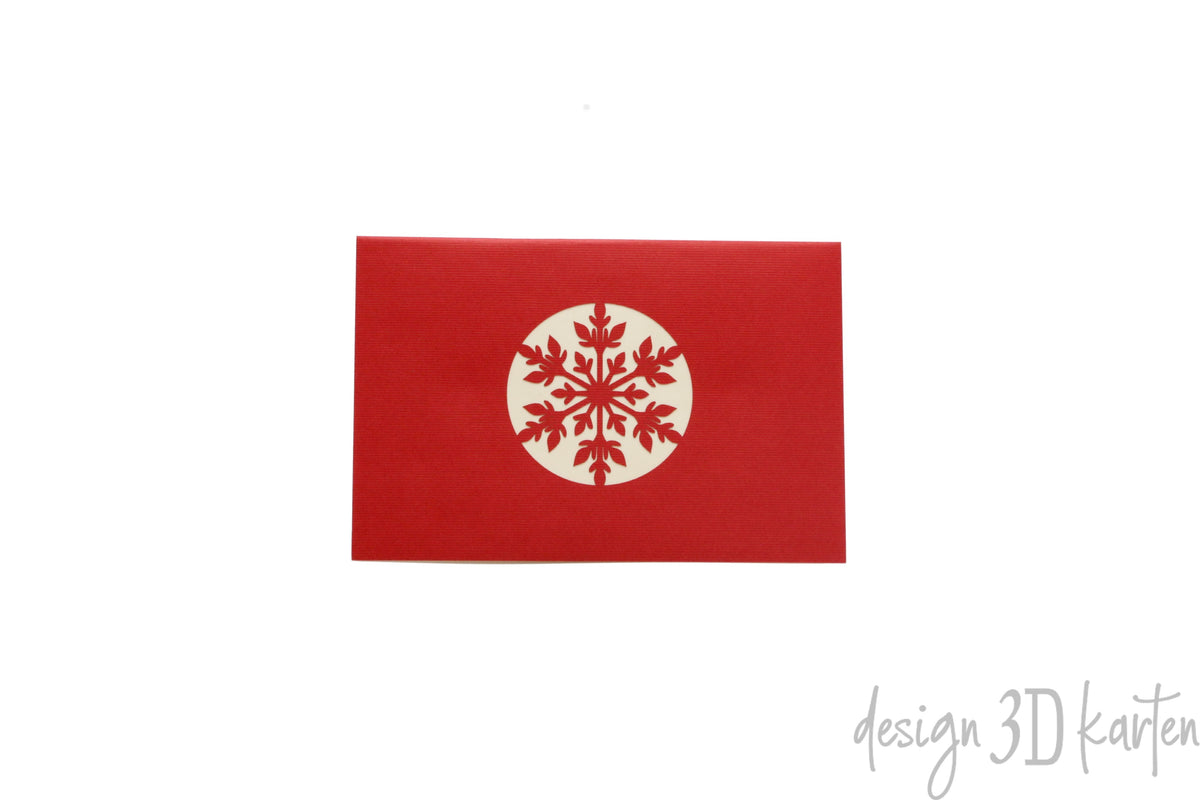 Rote Kartenvorderseite mit einer großen Schneeflocke in einem Kreis als Scherenschnitt.