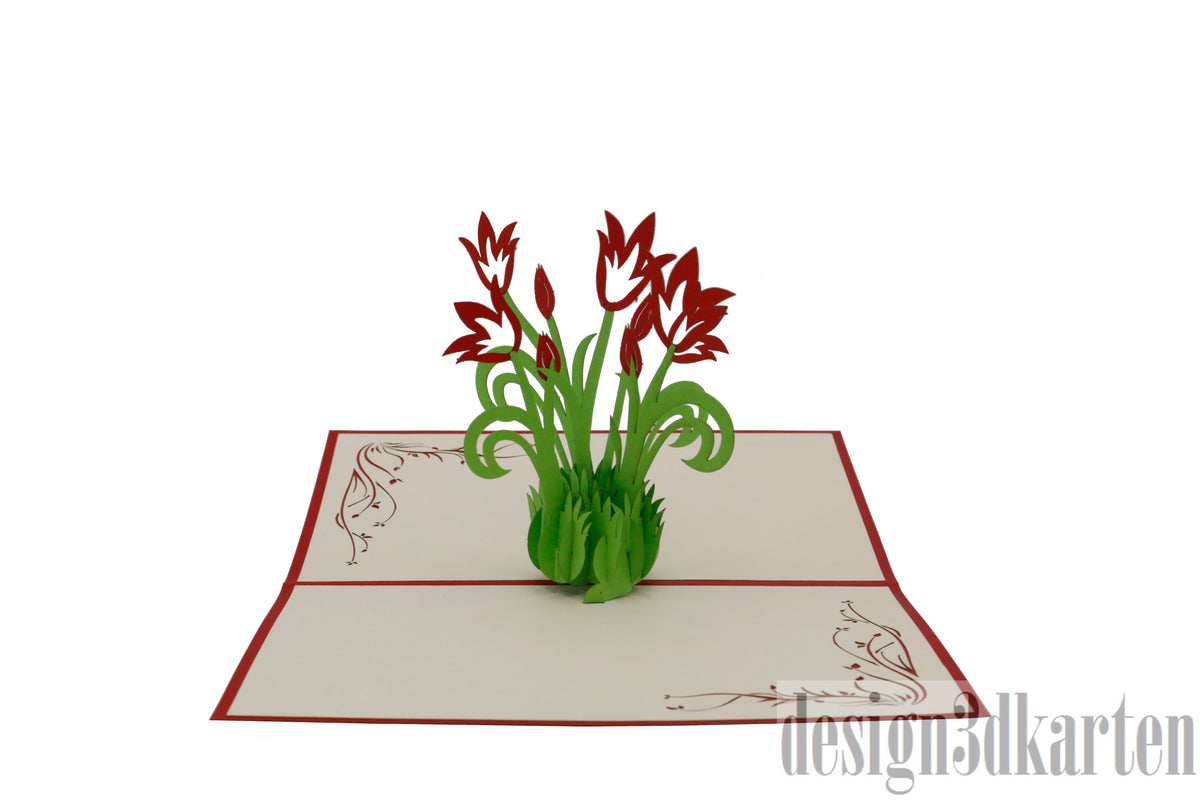 Aufgeklappte Pop-up-Karte mit roten Tulpen aus Papier, seitlich fotografiert.