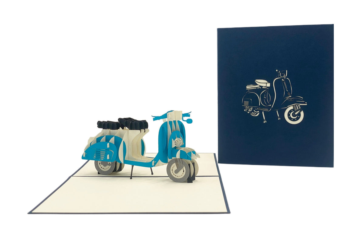 Aufgeklappte Pop-up-Karte mit blauer Vespa, daneben die dunkelblaue Kartenvorderseite mit Vespa-Scherenschnitt.