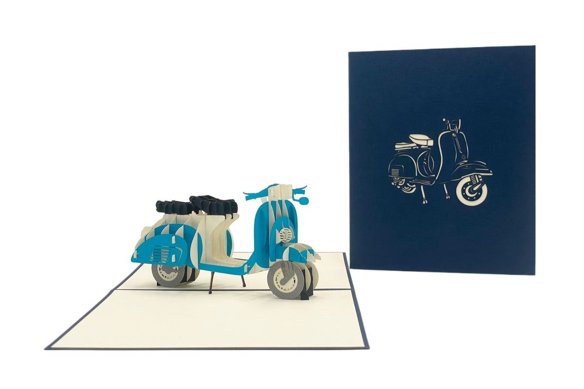 Aufgeklappte Pop-up-Karte mit blauer Vespa, daneben die dunkelblaue Kartenvorderseite mit Vespa-Scherenschnitt.