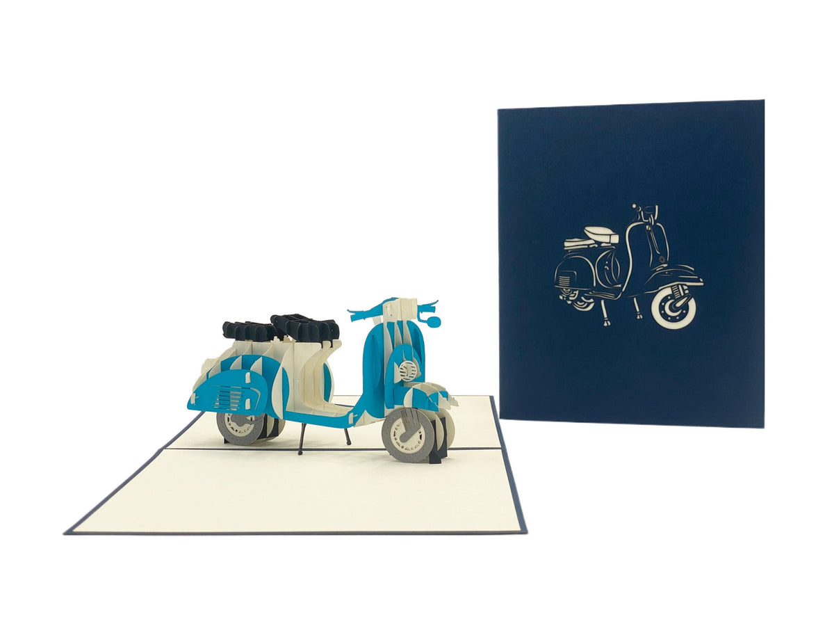 Aufgeklappte Pop-up-Karte mit blauer Vespa, daneben die dunkelblaue Kartenvorderseite mit Vespa-Scherenschnitt.