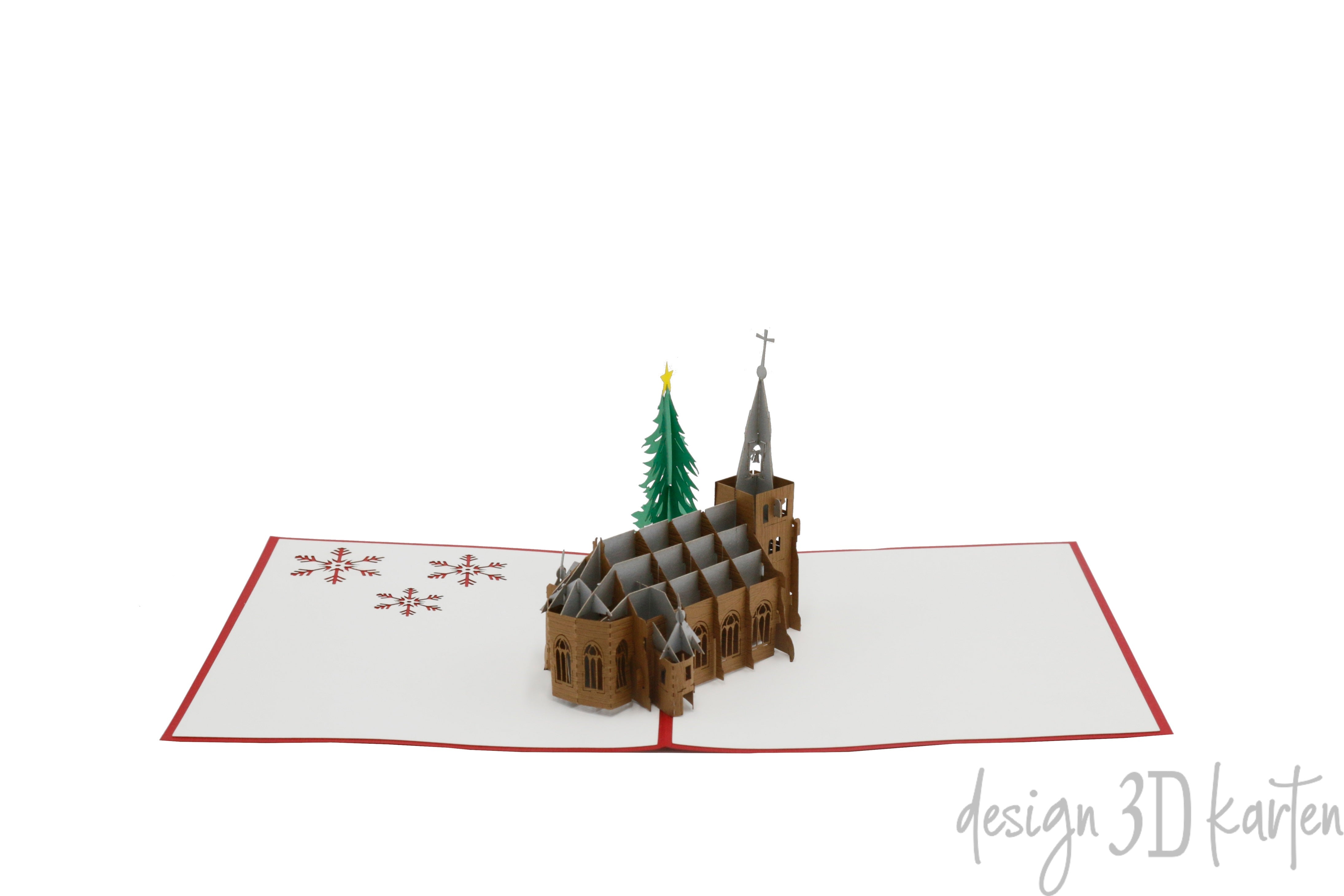Aufgeklappte Pop-up-Karte mit Kirche und Tannenbaum aus Papier, schräg von der Seite fotografiert.