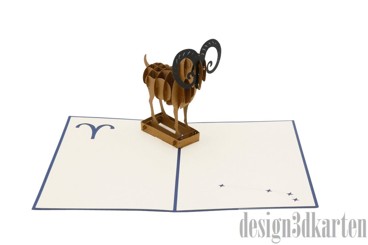 Aufgeklappte Pop-up-Karte mit einem Widder aus Papier, schräg von der Seite fotografiert.
