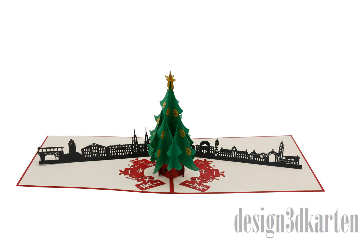 Aufgeklappte Pop-up-Karte mit grünem Weihnachtsbaum vor der Skyline von Wiesbaden.