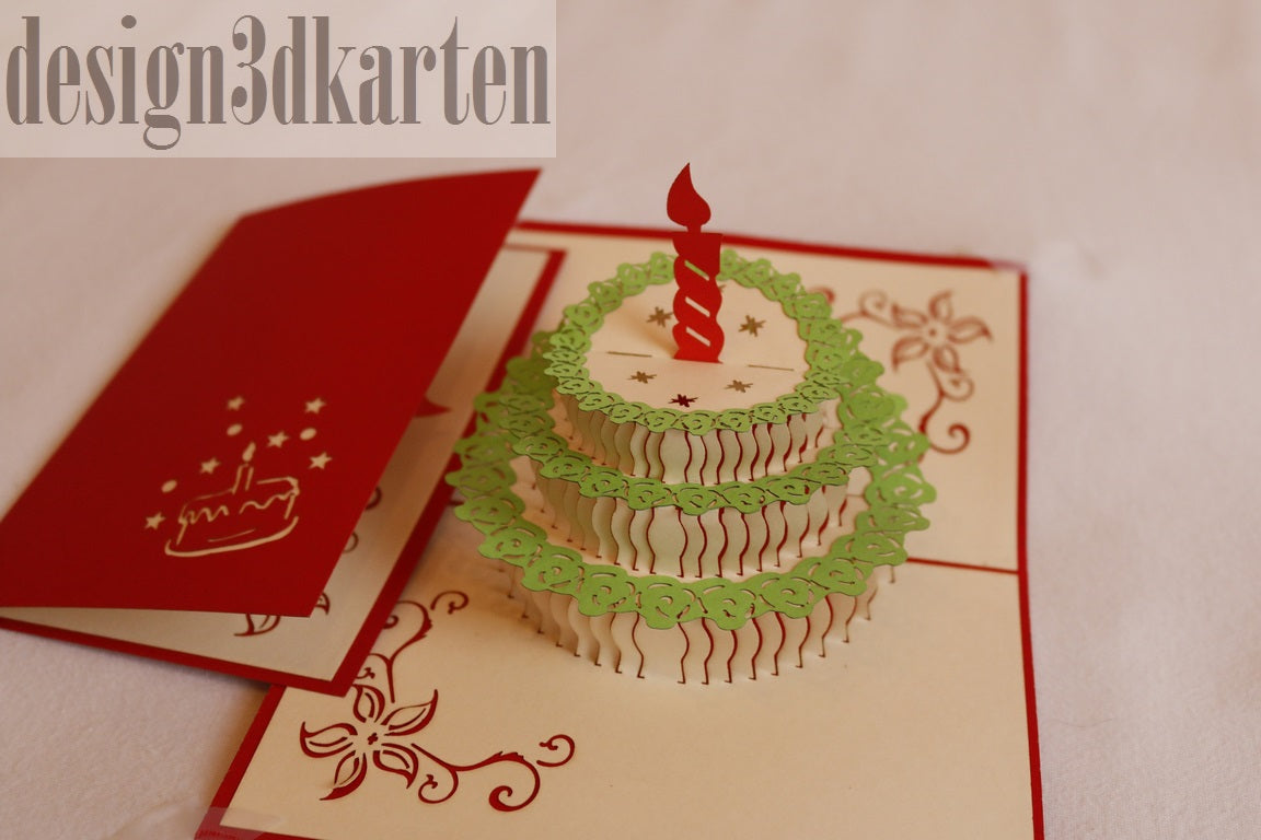Aufgeklappte Pop-up-Karte mit einer Torte mit grünem Spitzendekor und roter Kerze, daneben die rote Kartenvorderseite.