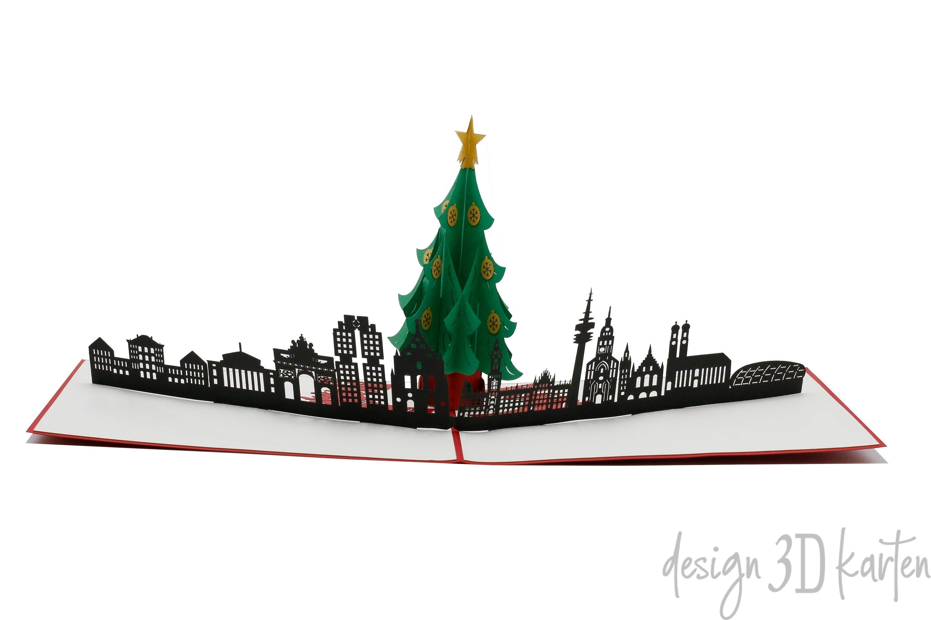 Aufgeklappte Pop-up-Karte mit grünem Weihnachtsbaum vor der Skyline von München, seitlich fotografiert.