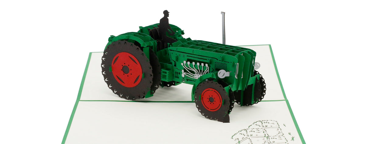 Aufgeklappte Pop-up-Karte mit grünem Rand und einem grünen Oldtimer-Traktor mit roten Felgen.