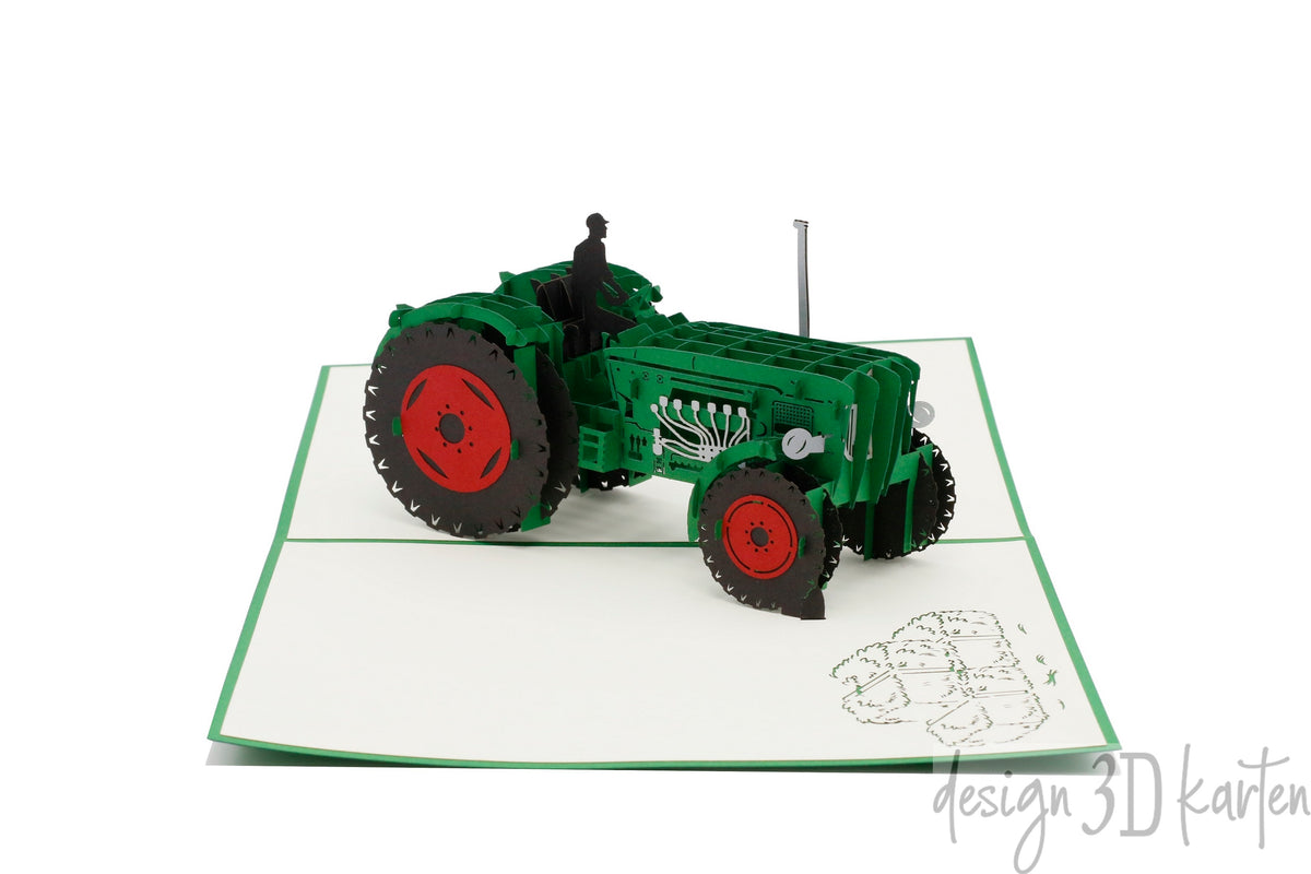 Aufgeklappte Pop-up-Karte mit grünem Rand und einem grünen Oldtimer-Traktor mit roten Felgen.