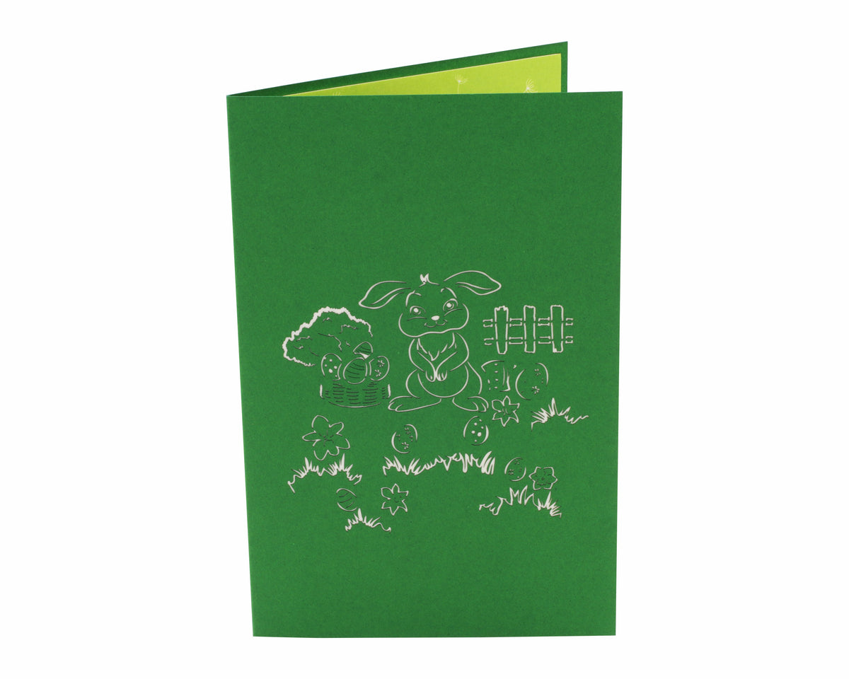 grüne klappkarte mit einem osterhasen im garten und ostereiern