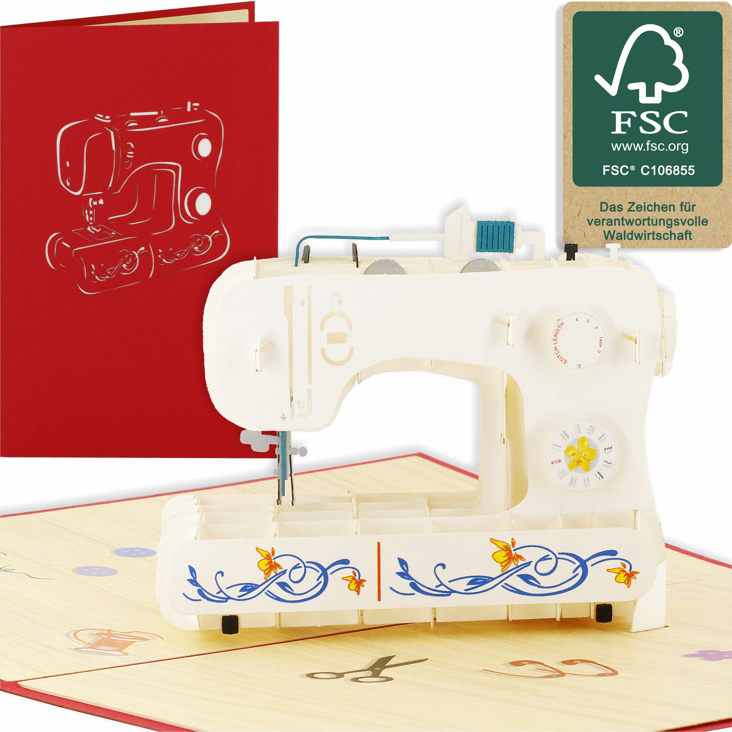 Aufgeklappte Pop-up-Karte mit einer weißen Nähmaschine mit Blumenmuster, daneben die rote Kartenvorderseite und das FSC-Logo.