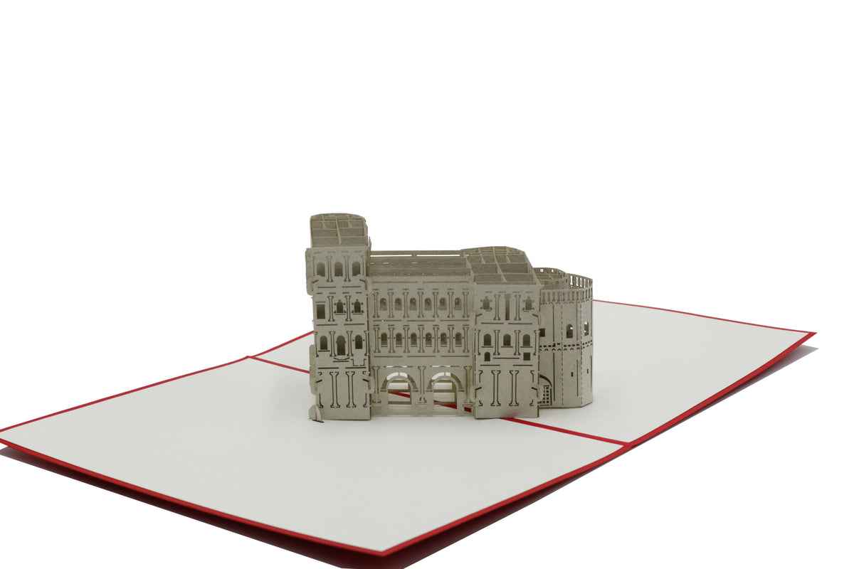 Aufgeklappte Pop-up-Karte mit der Porta Nigra aus Papier, schräg von der Seite fotografiert.
