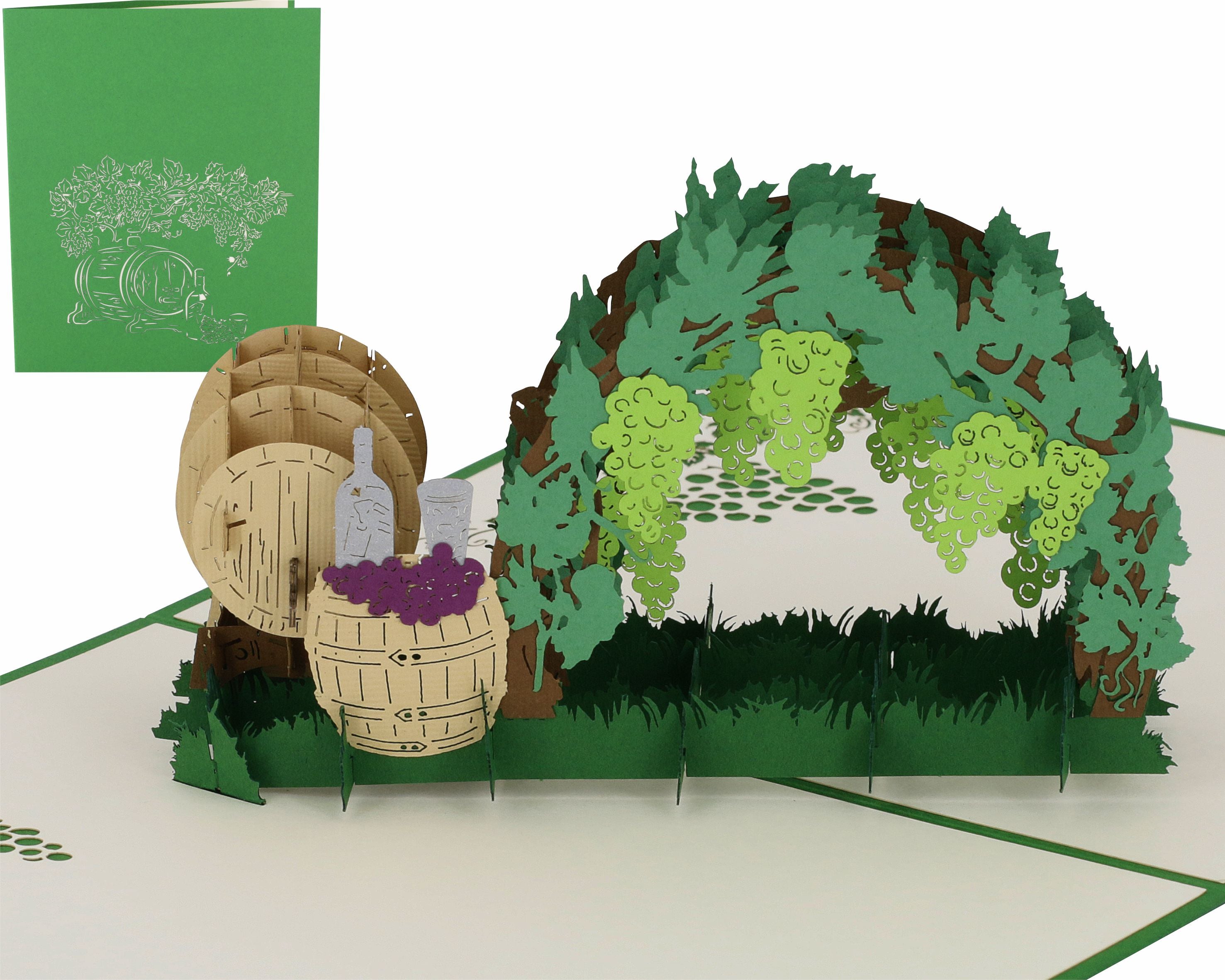 Aufgeklappte Pop-up-Karte mit einer Weinlaube mit Trauben, Weinfässern und Flasche, daneben die grüne Kartenvorderseite mit Weinreben-Scherenschnitt.