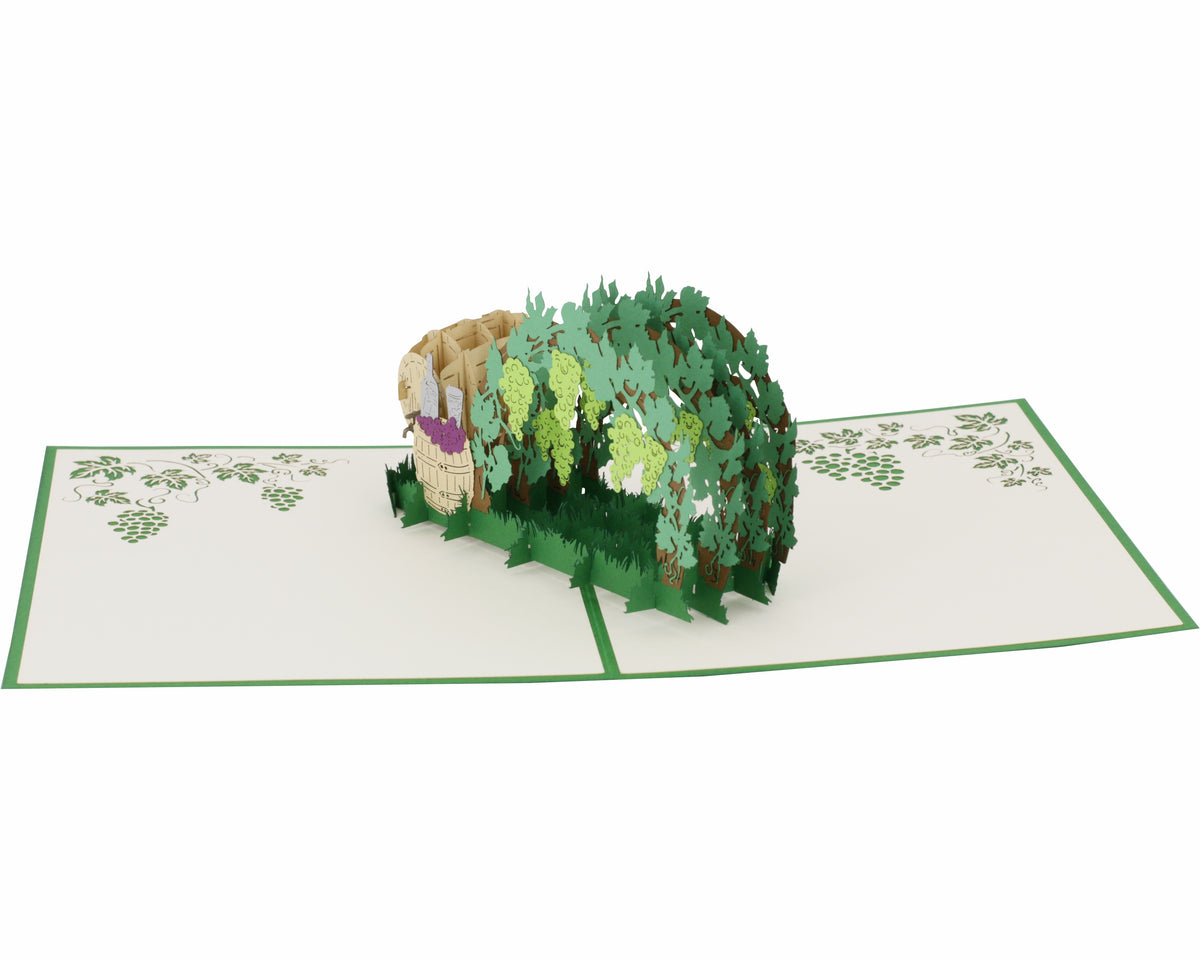 Aufgeklappte Pop-up-Karte mit Weinlaube und Weinfässern, schräg von oben fotografiert.