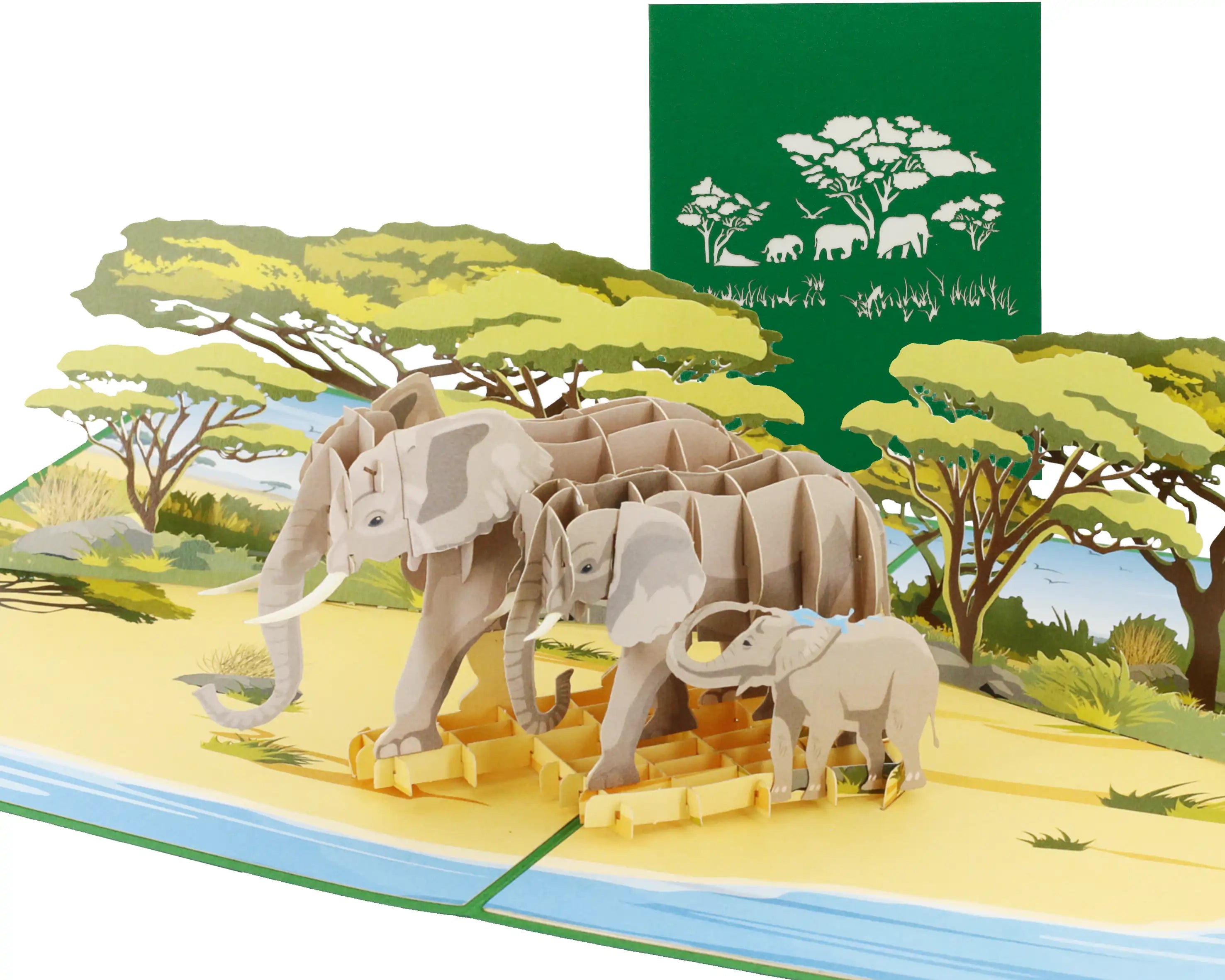 Aufgeklappte 3D Pop-up Karte Elefant: Elefantenfamilie mit Jungtier am Fluss in der afrikanischen Savanne unter Schirmakazien, dahinter die grüne Vorderseite mit Elefanten-Scherenschnitt