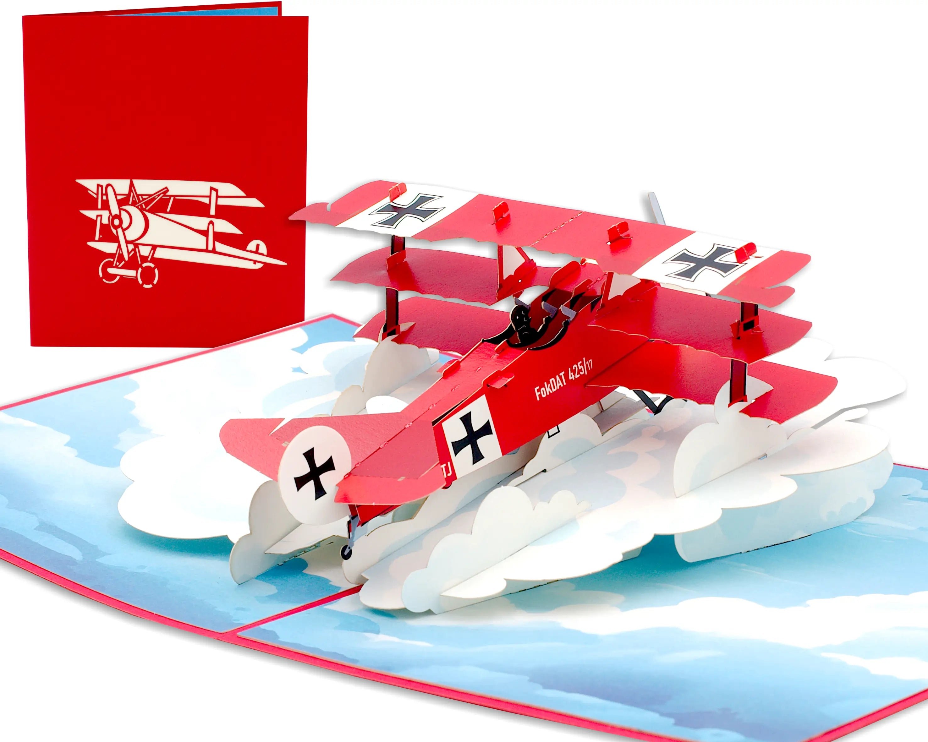 Aufgeklappte 3D Pop-up Karte Roter Baron: roter Fokker Dreidecker über weißen Wolken auf Himmelblau, daneben die rote Vorderseite mit Flugzeug-Scherenschnitt