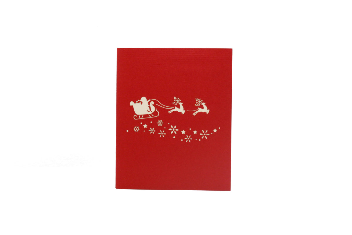 Rote Kartenvorderseite mit einem weißen Weihnachtsmann im Rentierschlitten und Schneeflocken als Scherenschnitt.