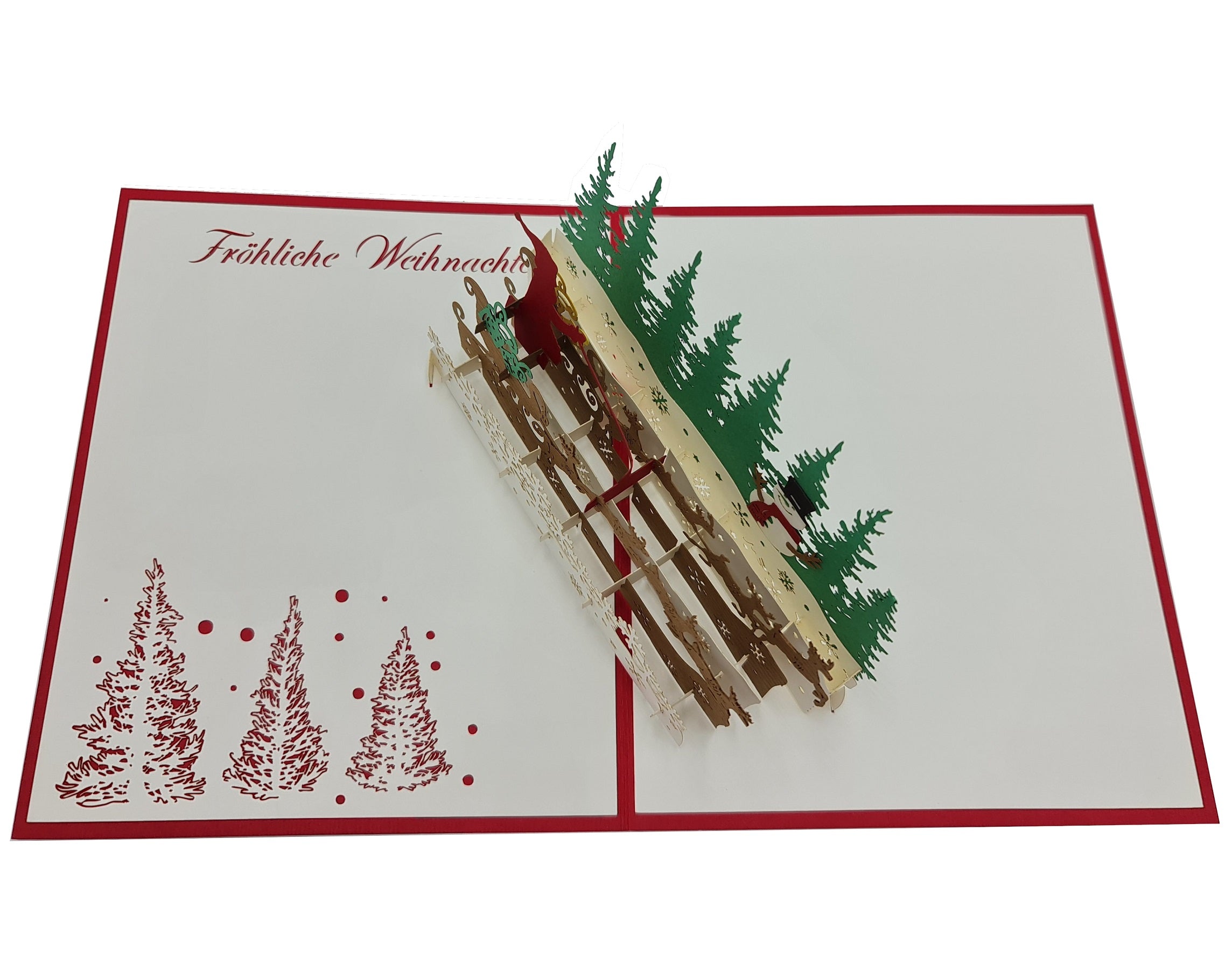 Aufgeklappte Pop-up-Karte mit Weihnachtsmann im Rentierschlitten, grünen Tannen und dem Schriftzug Fröhliche Weihnachten auf weißem Papier mit rotem Rand.