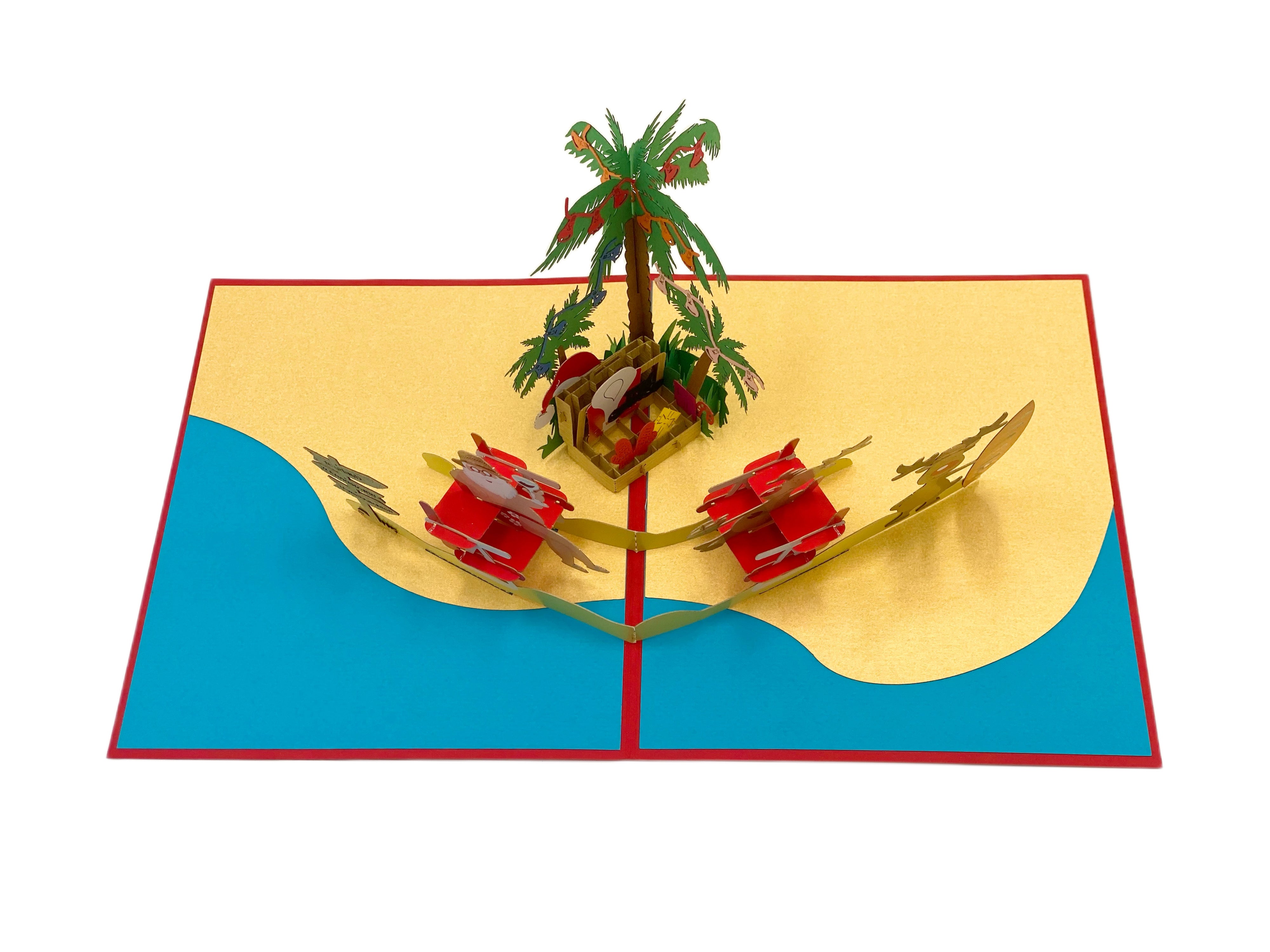 Aufgeklappte Pop-up-Karte von oben: Strandszene mit Palme, Weihnachtsmann und Rentieren auf gelbem Sand vor türkisem Meer.