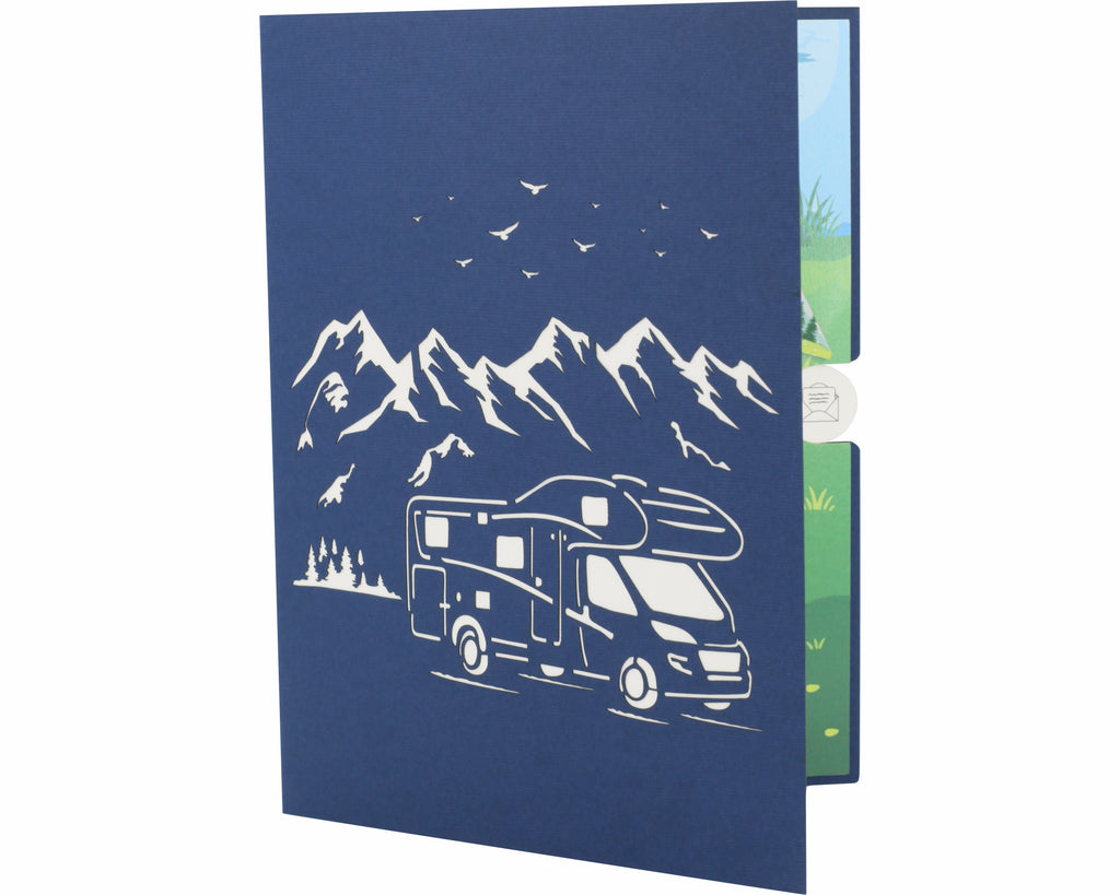 blaue karte mit einem wohnmobil als scherenschnitt in der natur vor bergen und vögeln