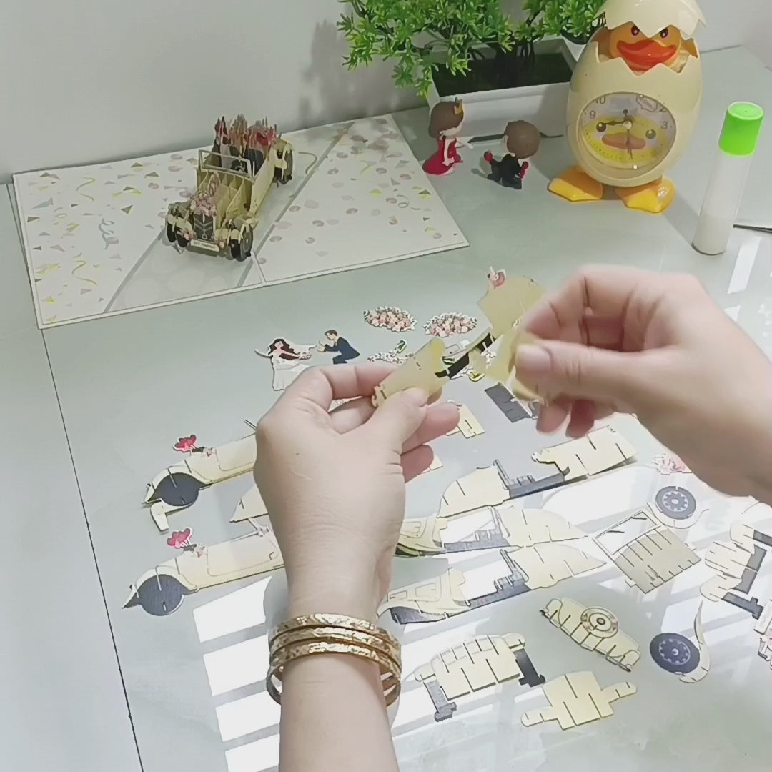 Video: Herstellung der Pop-up-Karte Hochzeitsauto – die weißen Papierteile des Autos werden von Hand zusammengesetzt.