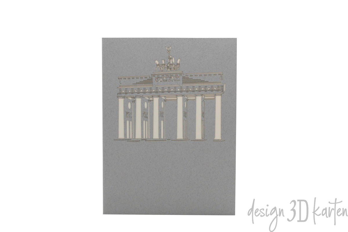 Graue Kartenvorderseite mit dem Brandenburger Tor als Scherenschnitt.