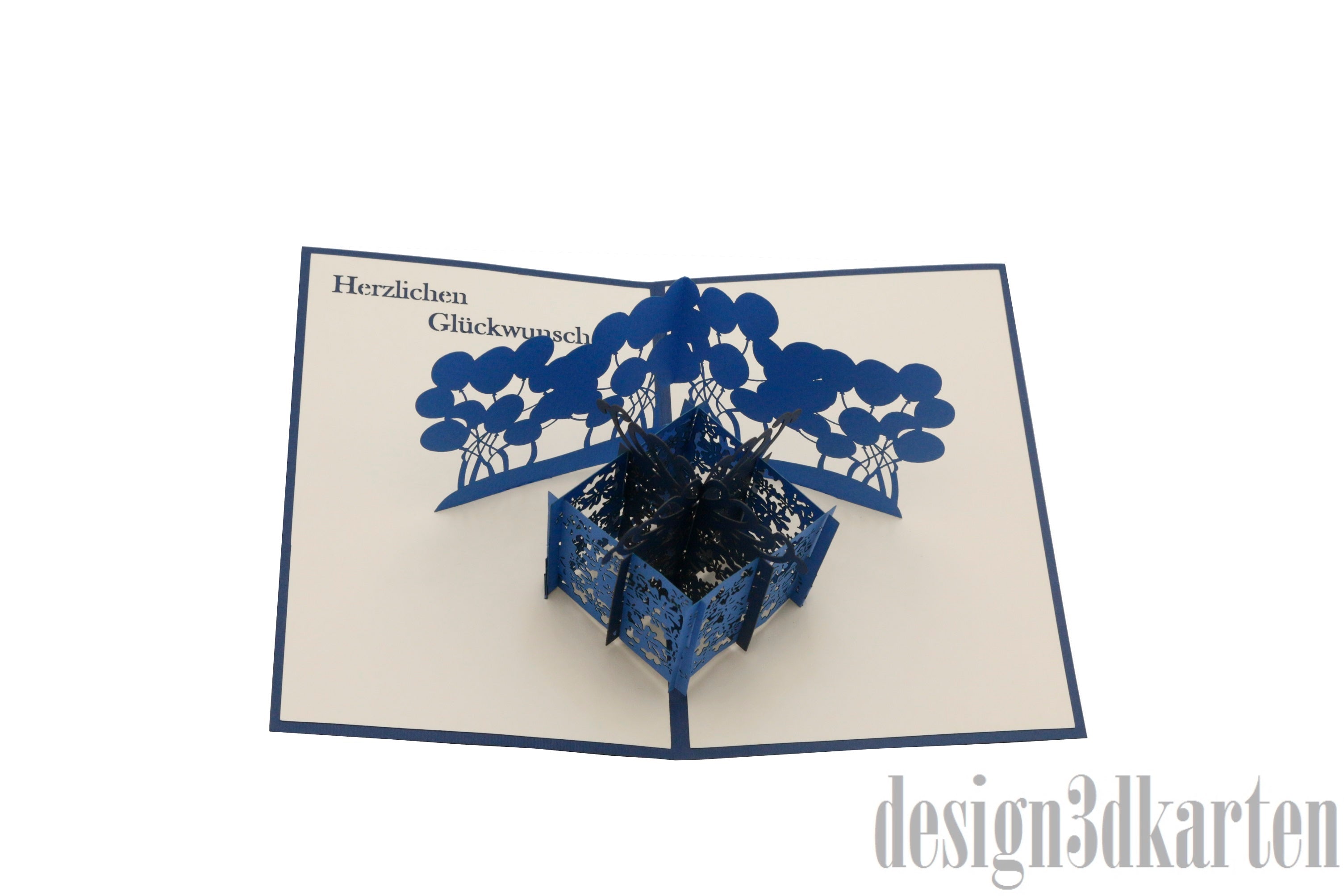 Aufgeklappte Pop-up-Karte mit dunkelblauem Rand: eine blaue Geschenkbox mit blauen Luftballons.