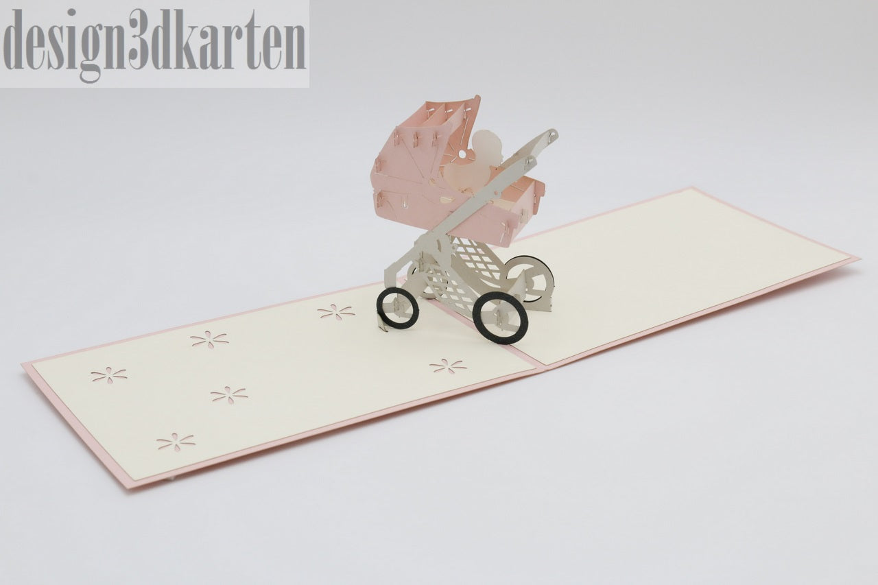 Aufgeklappte Pop-up-Karte mit rosa Kinderwagen, schräg von der Seite fotografiert.