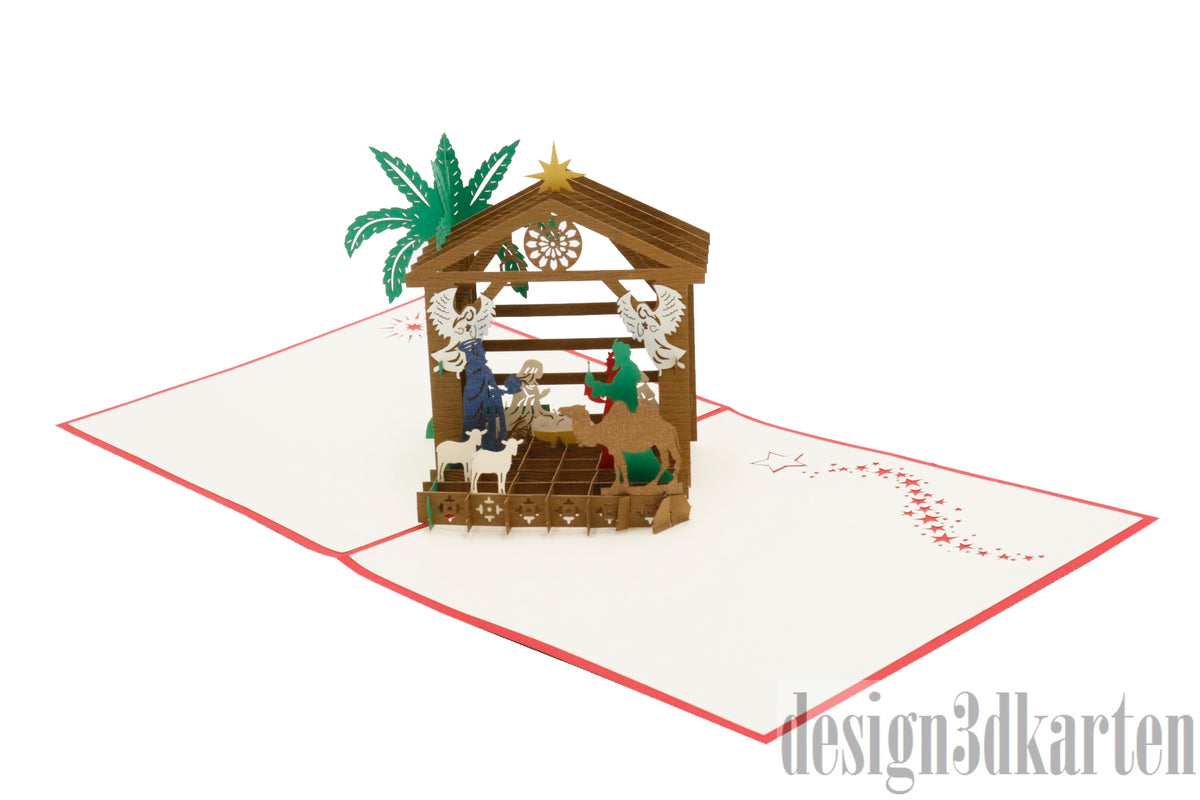 Aufgeklappte Pop-up-Karte mit rotem Rand und einer Weihnachtskrippe mit Stall, Palme und Figuren.