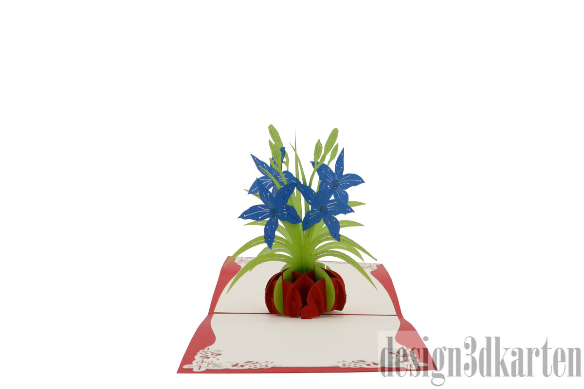Aufgeklappte Pop-up-Karte mit rotem Rand und einem Strauß blauer Lilien in einer roten Vase.