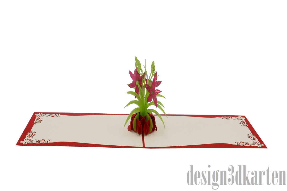Aufgeklappte Pop-up-Karte mit pinken Lilien in einer Vase, flach von vorne fotografiert.