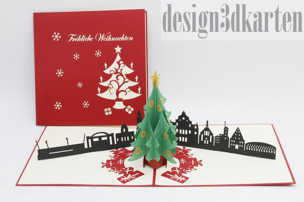 Aufgeklappte Pop-up-Karte mit Weihnachtsbaum und Nürnberger Skyline, daneben die rote Kartenvorderseite mit Weihnachtsbaum-Scherenschnitt.