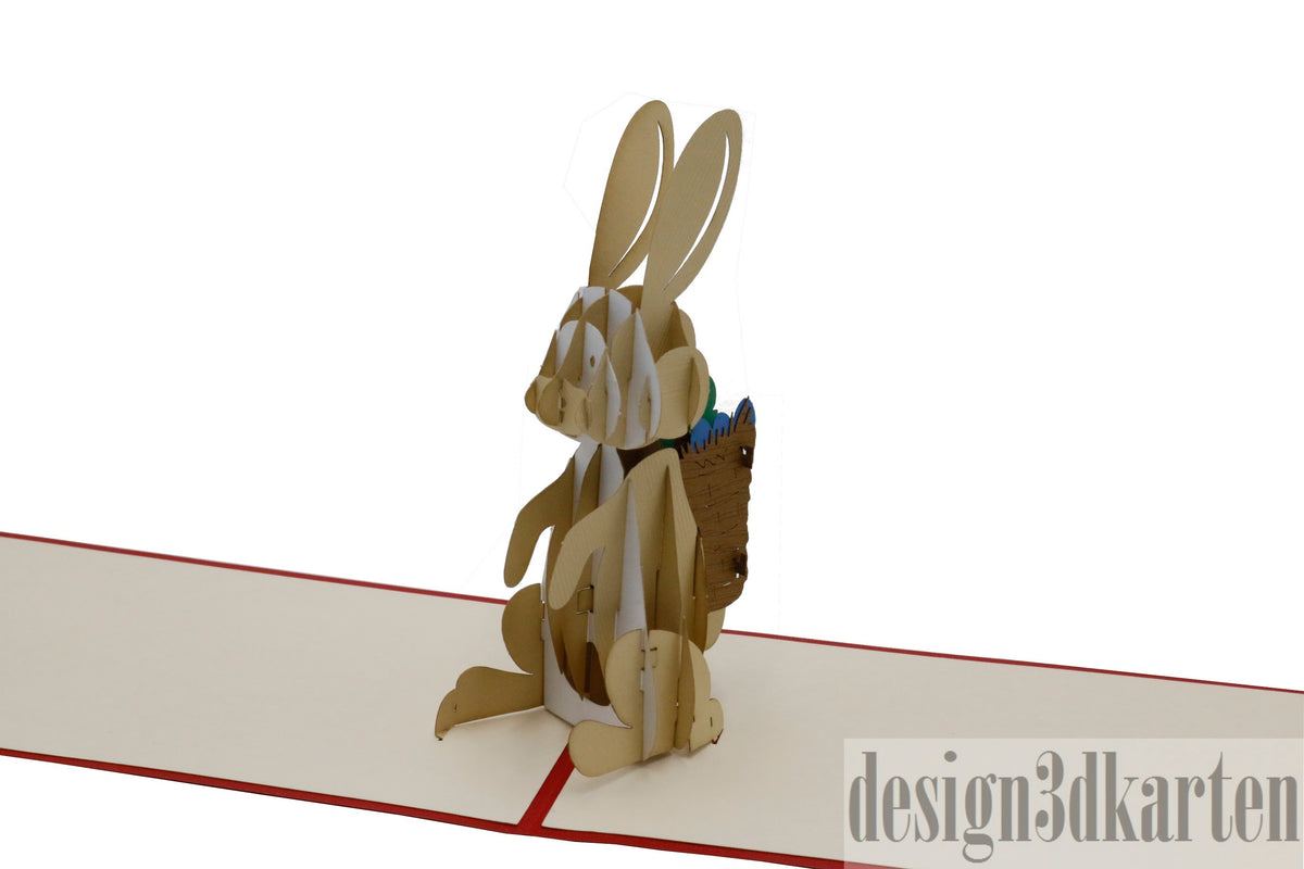 Aufgeklappte Pop-up-Karte mit einem Osterhasen aus Papier, frontal fotografiert.