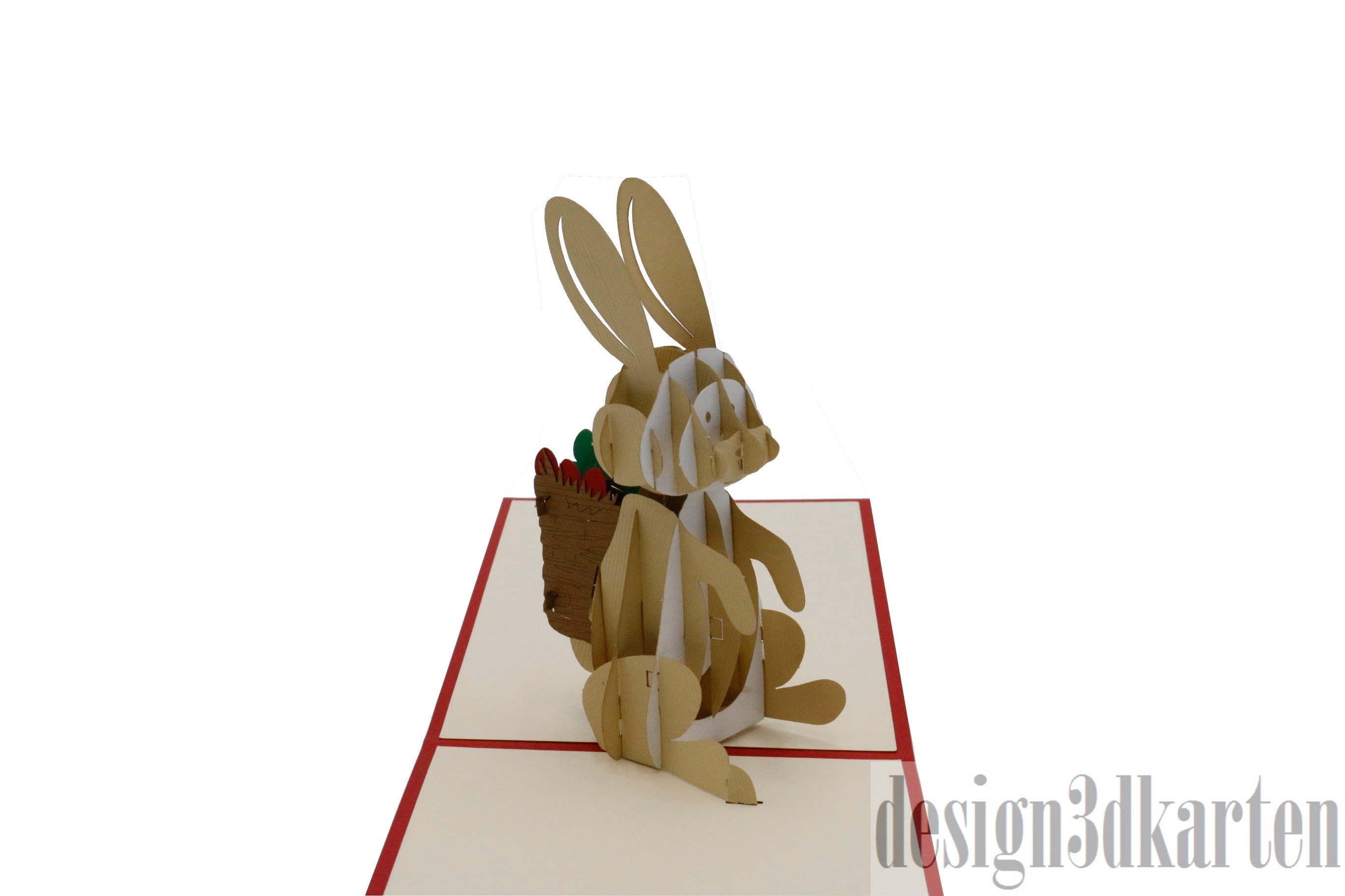 Aufgeklappte Pop-up-Karte mit rotem Rand und einem sitzenden Osterhasen mit einem Korb voller bunter Ostereier.