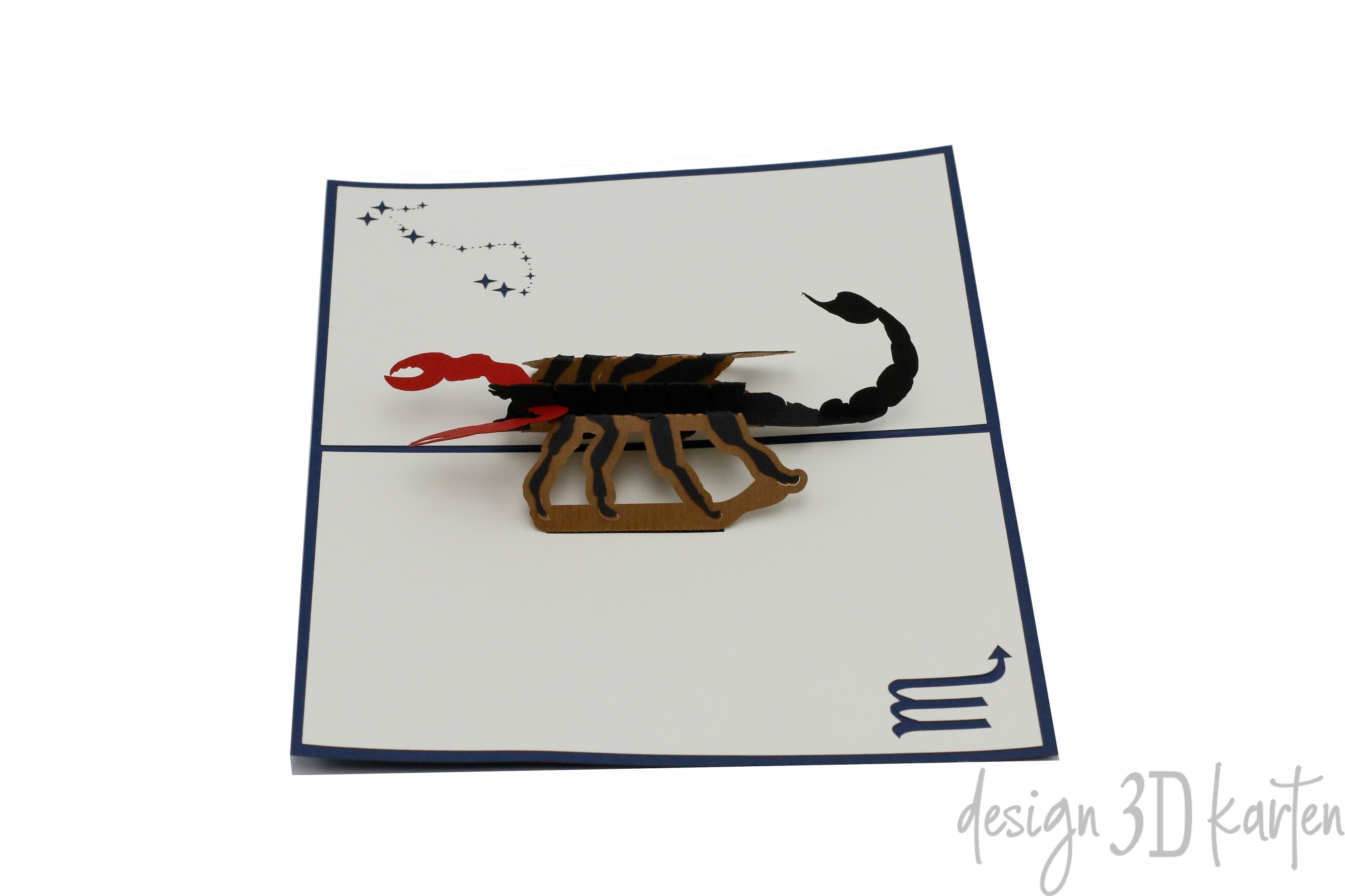 Aufgeklappte Pop-up-Karte mit Skorpion und Sternbild auf der Kartenfläche, von oben fotografiert.