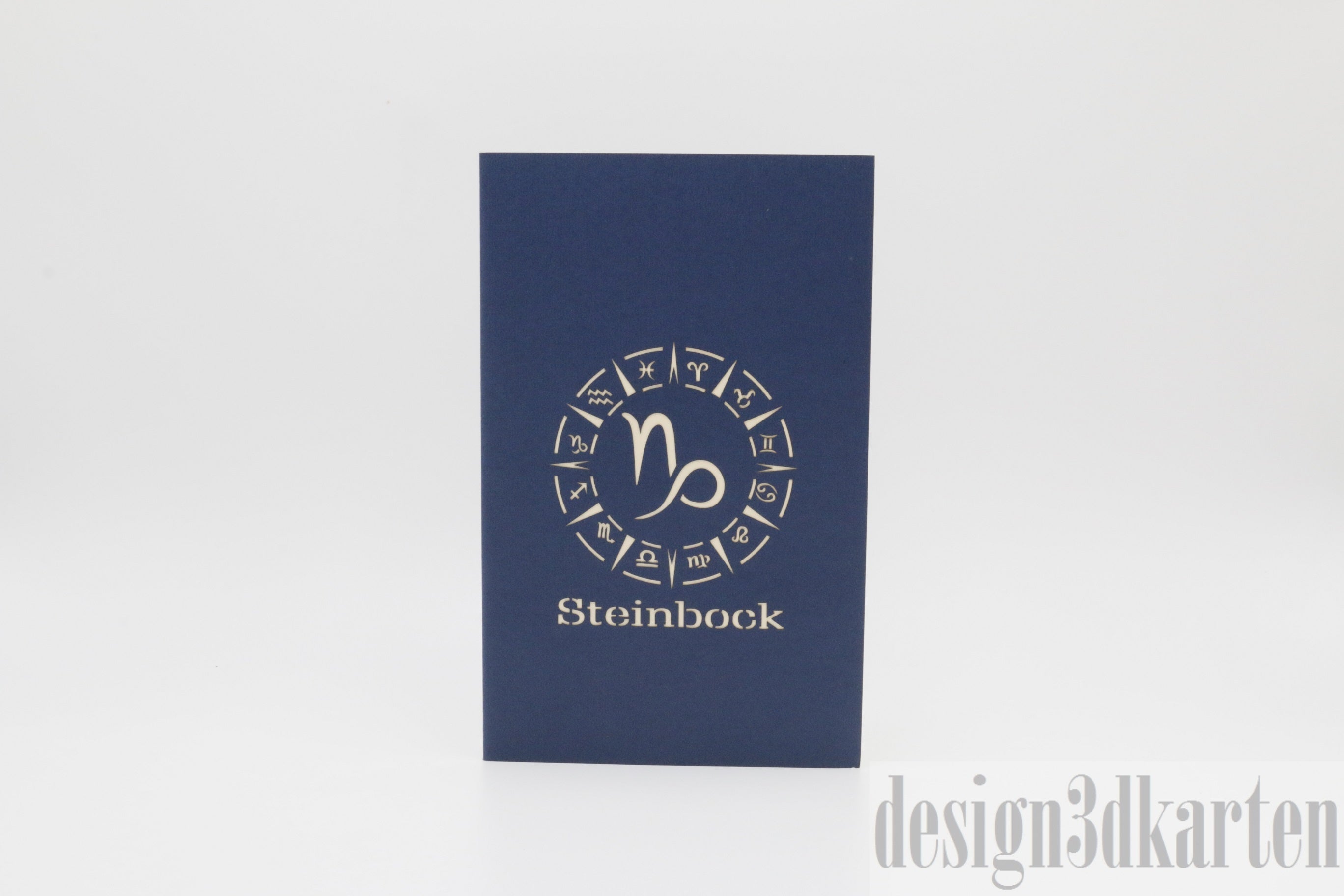 Dunkelblaue Kartenvorderseite mit dem Sternzeichen Steinbock im Tierkreisrad und dem Schriftzug Steinbock.