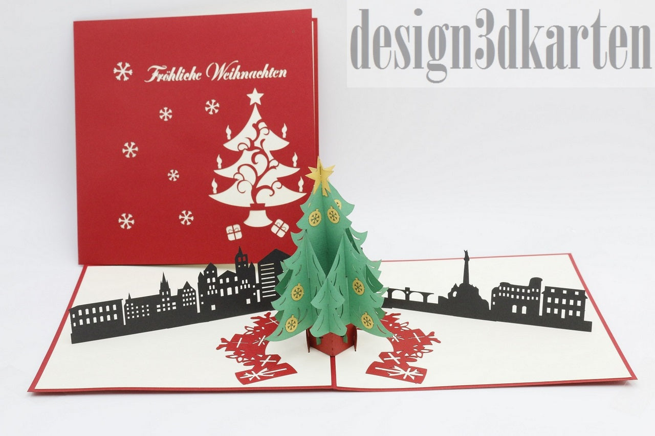 Aufgeklappte Pop-up-Karte mit Weihnachtsbaum und Trierer Skyline, daneben die rote Kartenvorderseite mit Weihnachtsbaum-Scherenschnitt.