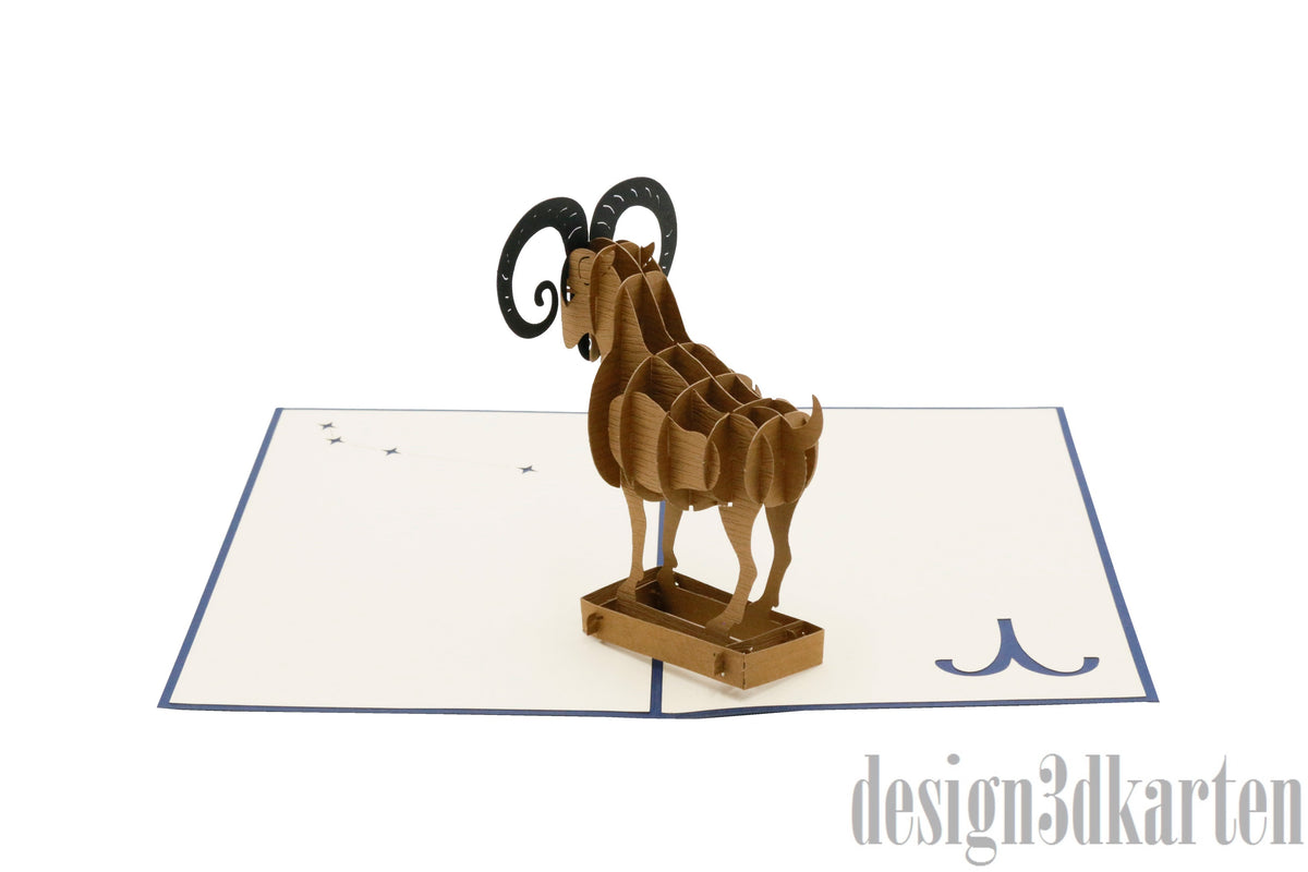 Aufgeklappte Pop-up-Karte mit einem Widder mit großen gebogenen Hörnern, daneben Symbol und Sternbild Widder.