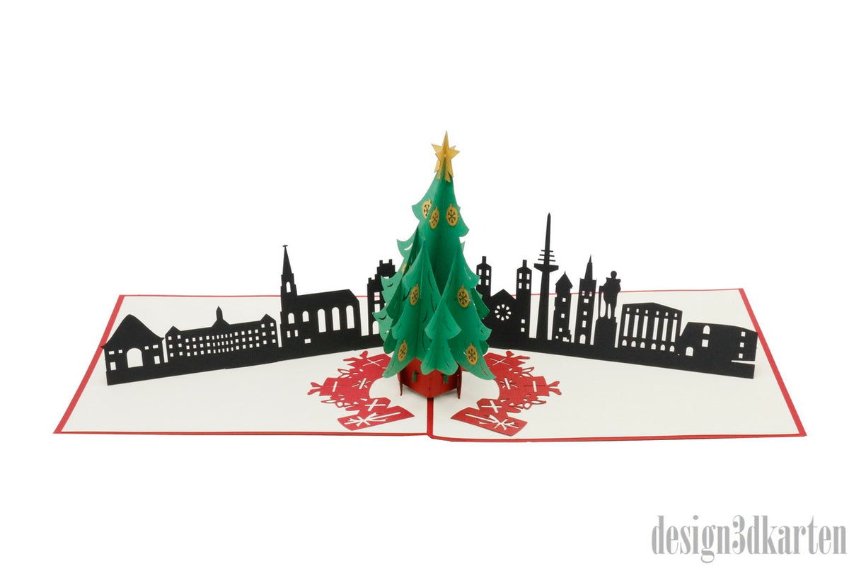 Aufgeklappte Pop-up-Karte mit grünem Weihnachtsbaum vor der Skyline von Münster.