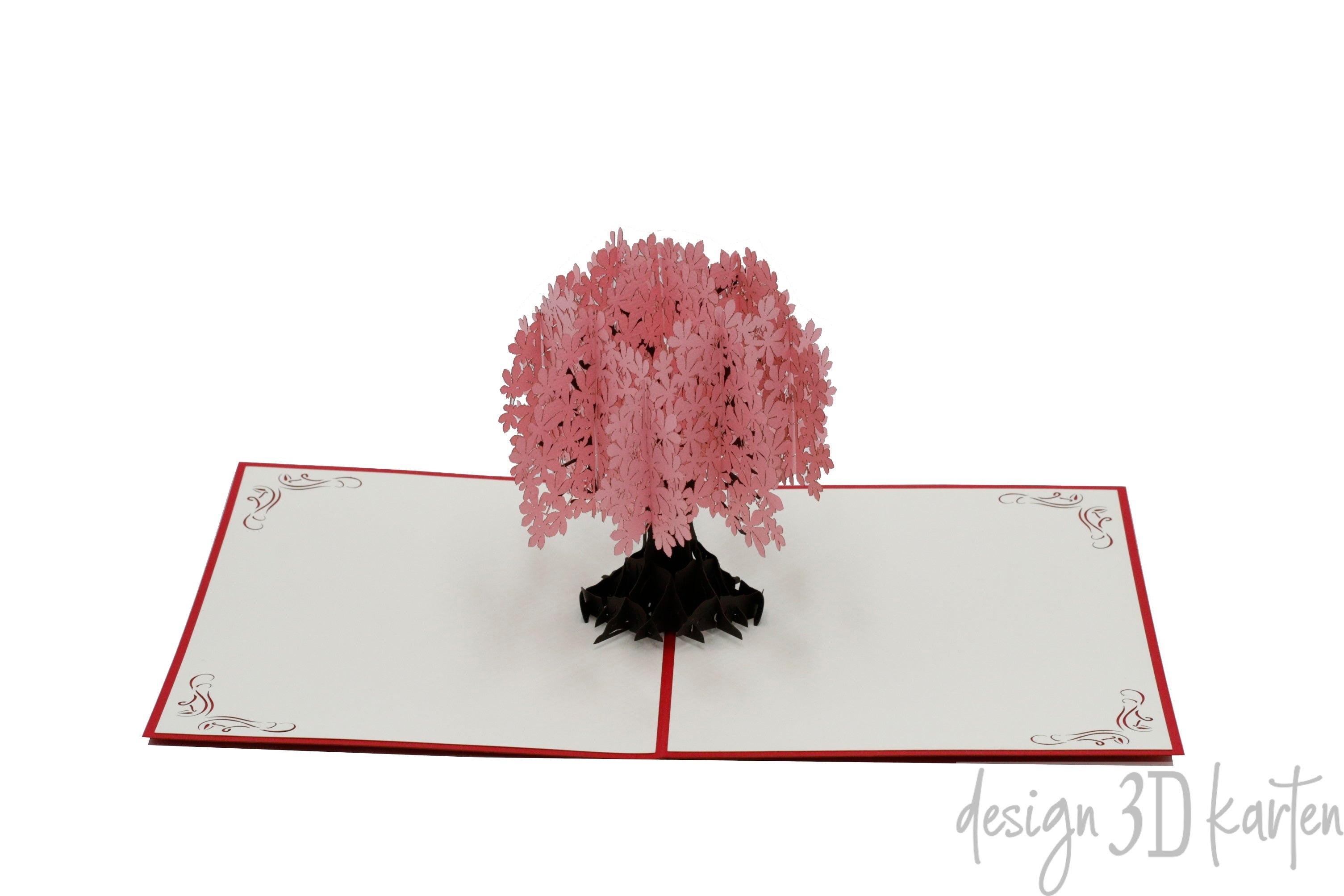 Aufgeklappte Pop-up-Karte mit rosa Blütenbaum aus Papier, seitlich fotografiert.