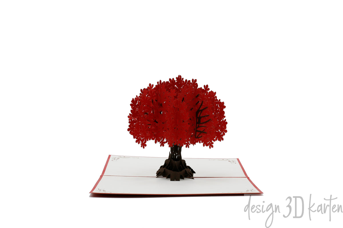 Aufgeklappte Pop-up-Karte mit rotem Rand und einem Baum mit roter Blütenkrone.